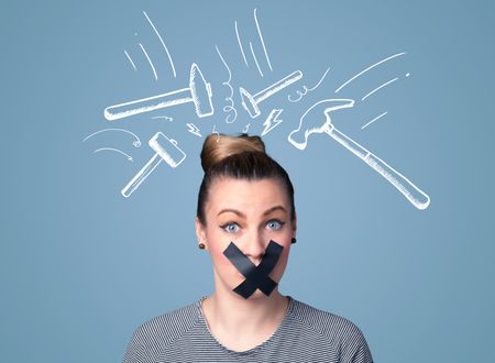 Young woman with taped mouth and white drawn beating hammer marks around her head