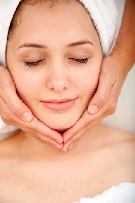 Beautiful relaxed woman getting a facial massage