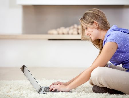 Woman sitting on the floor working with a laptop
