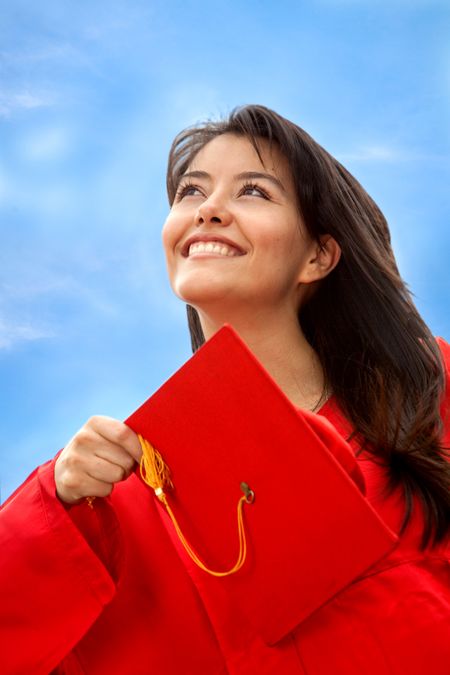 Female graduate throwing the mortarboard outdoors