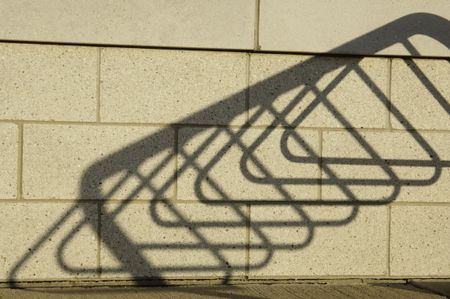 Shadow of bicycle stand on brick wall of public library