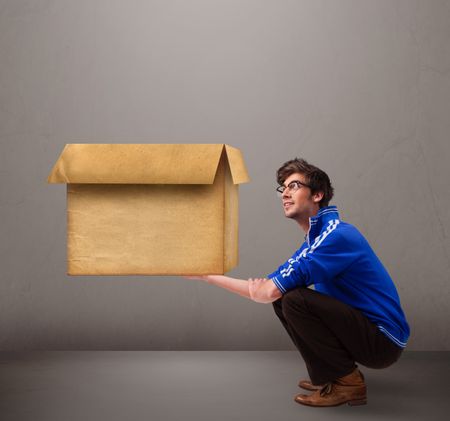 Goog-looking young man holding an empty brown cardboard box