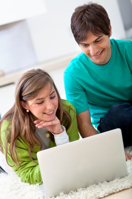 Couple working with a laptop and smiling