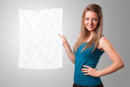 Beautiful young girl holding crumpled white paper copy space