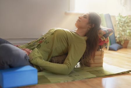 Attractive mixed race woman doing restorative yoga