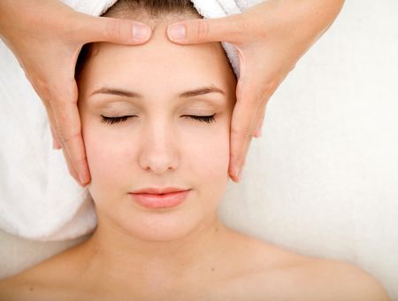 Woman at a spa getting massage on her face