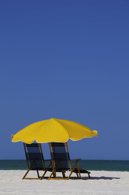 Classic beach umbrella over two recliners in Clearwater Beach, Florida
