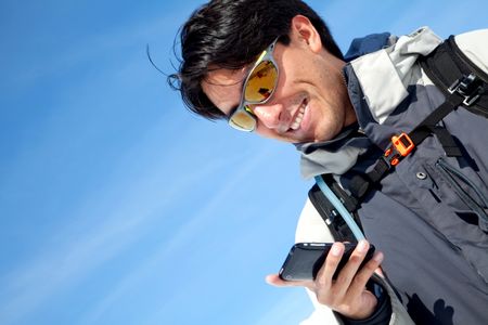 portrait of a man texting outdoors and smiling