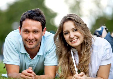 Casual couple portrait lying outdoors and smiling