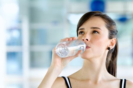 Gym woman drinking water from a bottle