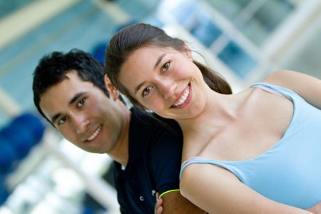 Portrait of a young couple at the gym smiling