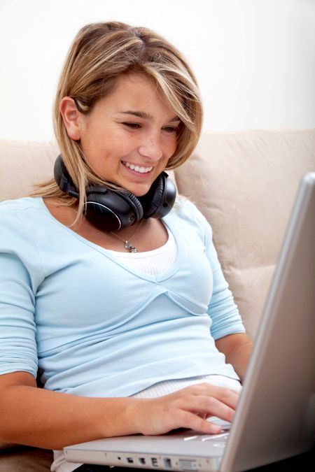 Woman on the computer with headphones at home