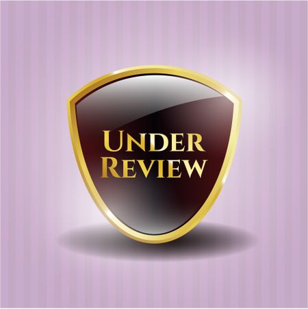 Under Review gold badge or emblem