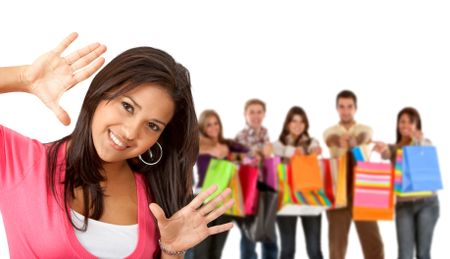 Beautiful girl in front of a group of happy shoppers with shopping bags isolated