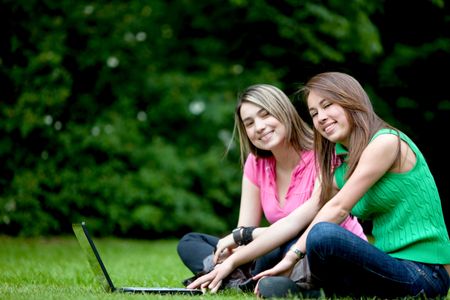 women outdoors with a laptop computer and smiling