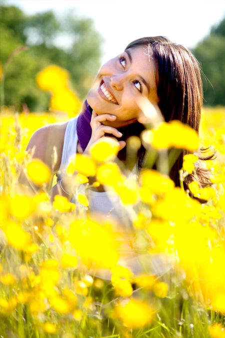 Pensive woman sitting on a beautiful meadow