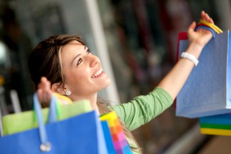 Happy woman with her arms opened holding shopping bags