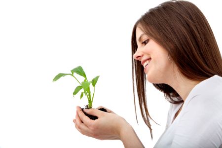 Woman holding a plant isolated over a white background