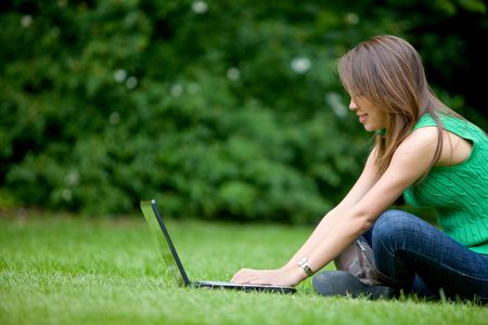 Casual woman working with a laptop outdoors