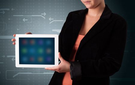 Young woman holding a white tablet with blurry apps