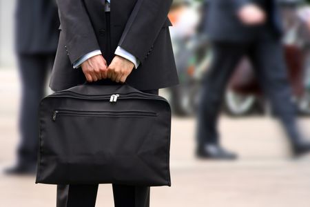 business man holding a briefcase in a fast moving corporate environment