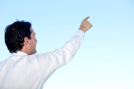 Businessman pointing something in a blue sky outdoors