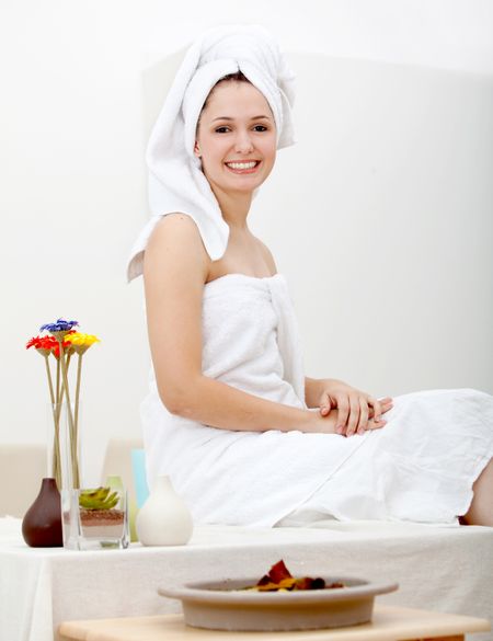 Beautiful happy woman with a towel on her head at the spa