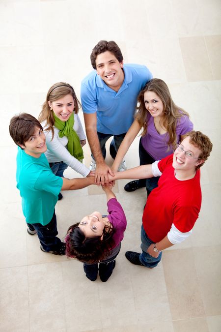 Happy group of friends with hands together on the middle