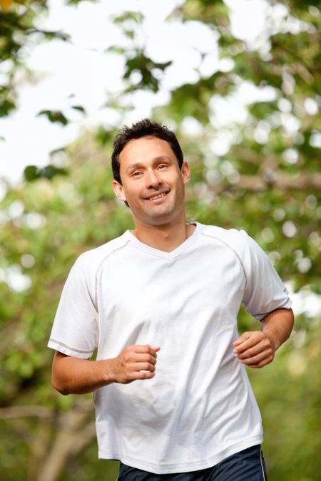 Fit man jogging outdoors at the park