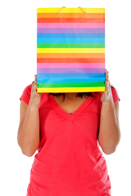 Girl covering her face with a shopping bag isolated on white