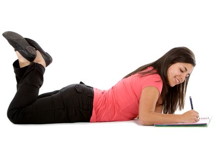 Female student lying on the floor writing - isolated