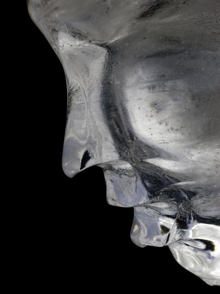 Profile of human face in ice against a black background
