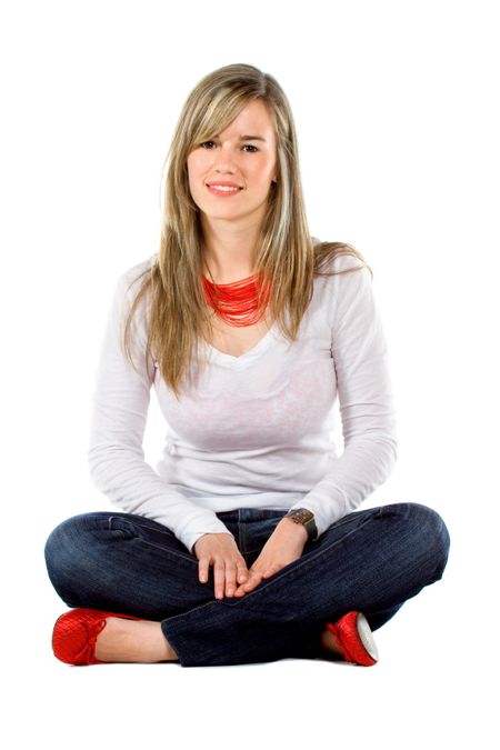 casual woman sitting on the floor and smiling isolated over a white background