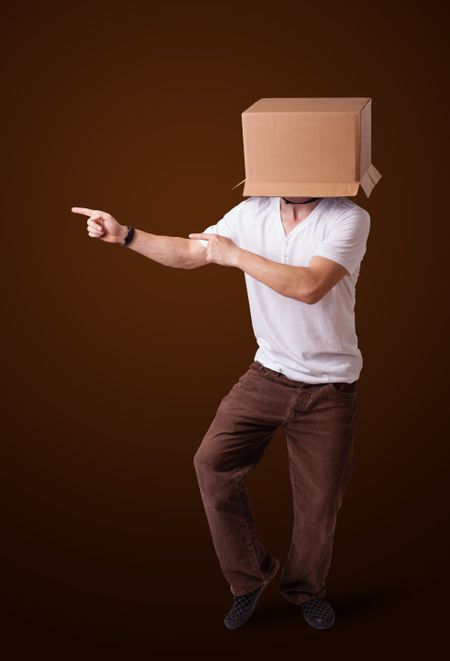 Young man standing and gesturing with a cardboard box on his head