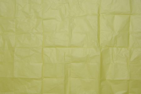 Texture of yellow wrapping paper once folded into squares