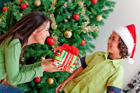Woman giving a Christmas present to a boy