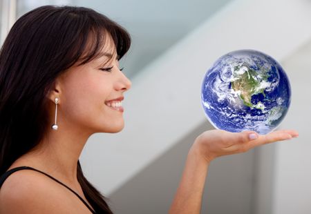 Beautiful business woman smiling and holding globe on her hand