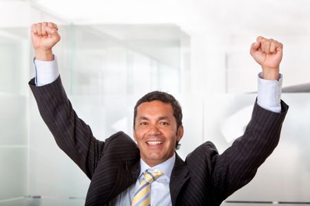business man smiling full of success with his arms up