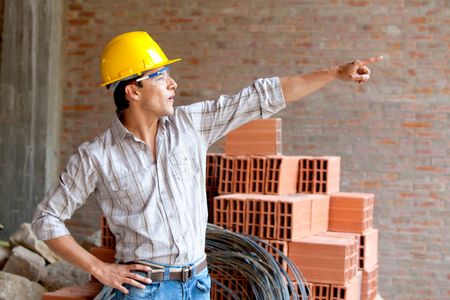 Construction worker at a building site pointing at something