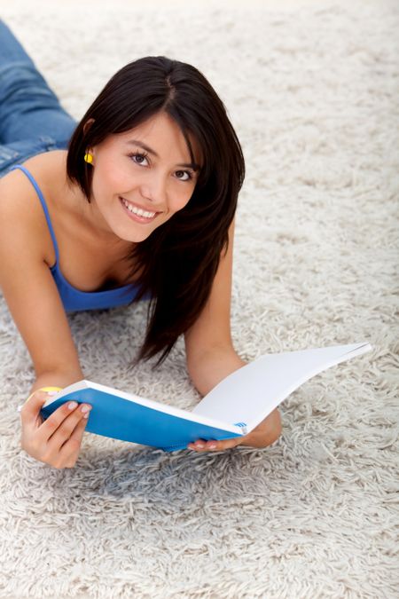 Female student lying on the floor with a notebook