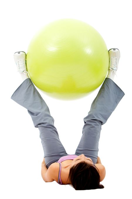 Woman exercising with a pilates ball - isolated over a white background