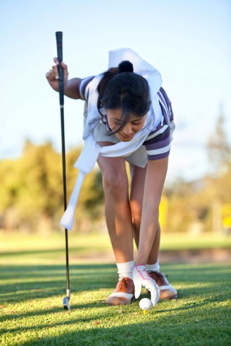 Young woman playing golf in a country club