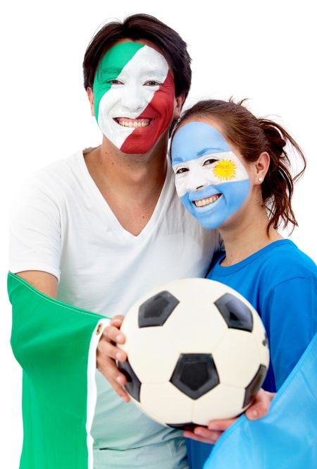 Couple of football fans holding a soccer ball and looking happy with their faces painted - Isolated over white