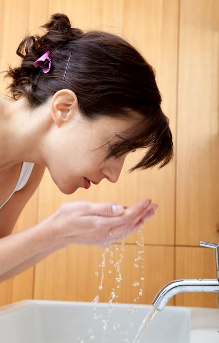 Beautiful portrait of a girl washing her face - Beauty concepts