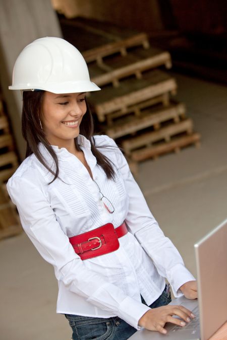 Female engineer with on a laptop computer in a construction site