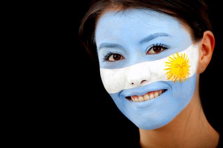 Portrait of a woman with the argentinian flag painted on her face isolated over a black background