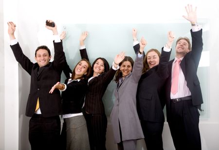 successful business team in an office looking happy with arms up