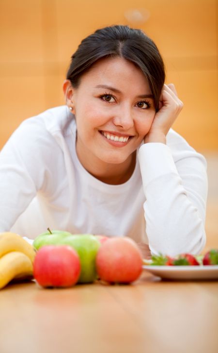 Healthy eating woman with fruits and smiling