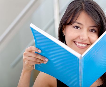 Business woman holding a notebook and smiling