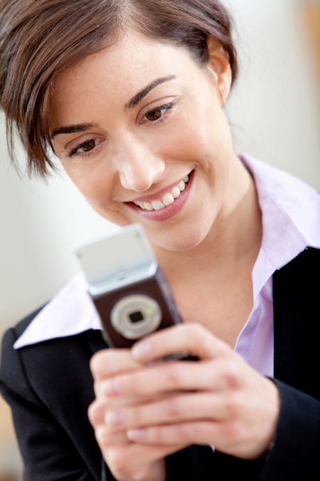 Business woman texting from her cell and smiling